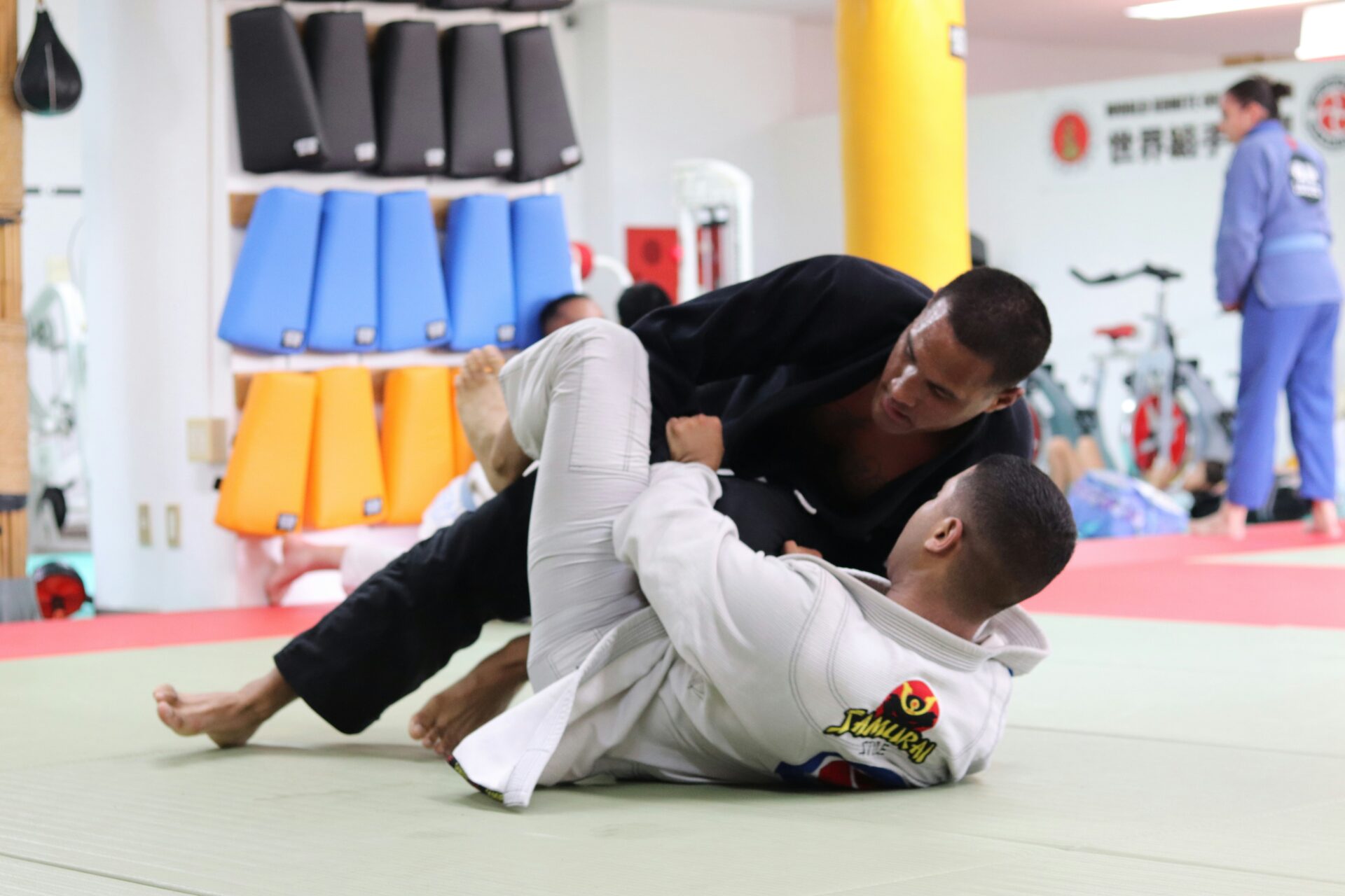 A man demonstrates a Brazilian Jiu-Jitsu maneuver, depicted in a dramatic black and white style A man demonstrates a Brazilian Jiu-Jitsu maneuver, depicted in a dramatic black and white style